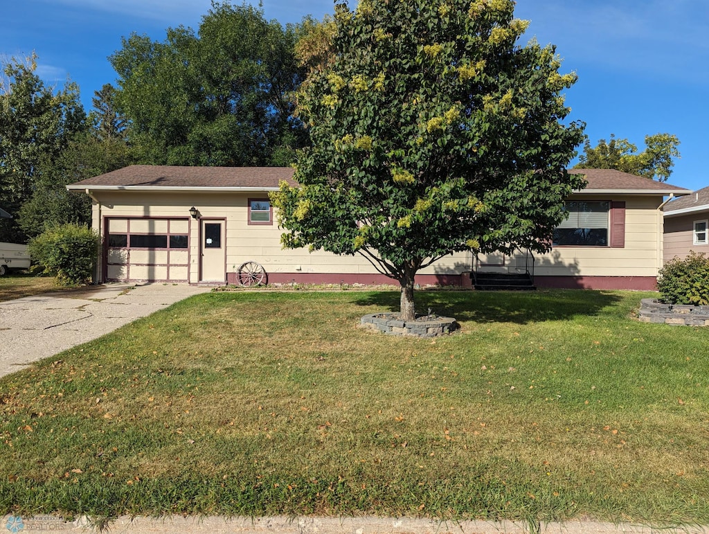 obstructed view of property featuring a garage and a front lawn