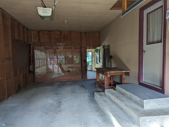 garage featuring a garage door opener and wood walls