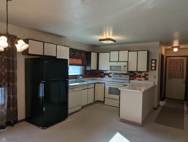 kitchen with white appliances, white cabinetry, hanging light fixtures, and sink