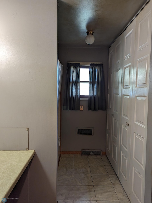 hall with light tile patterned floors