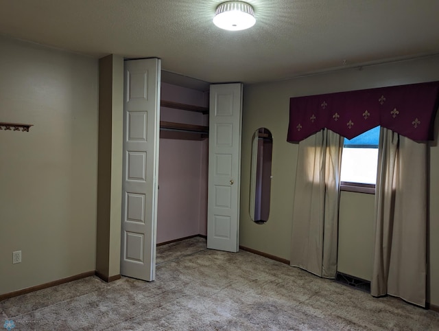 unfurnished bedroom with light colored carpet, a textured ceiling, and a closet