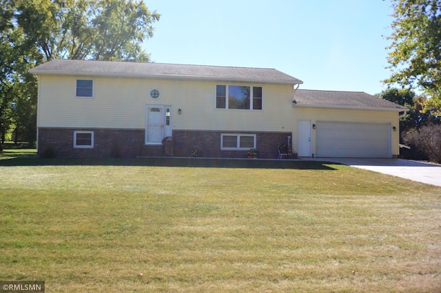 raised ranch featuring a garage and a front lawn