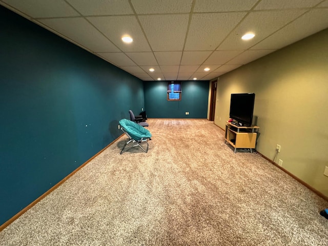 interior space with a paneled ceiling and carpet