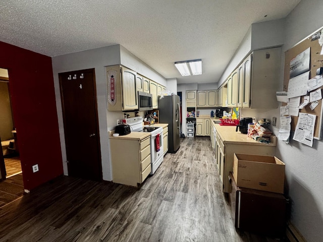 kitchen featuring a skylight, cream cabinets, hardwood / wood-style floors, a textured ceiling, and appliances with stainless steel finishes