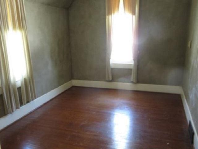 unfurnished room with dark hardwood / wood-style floors