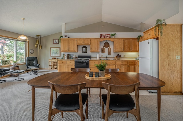 carpeted dining room featuring vaulted ceiling and sink