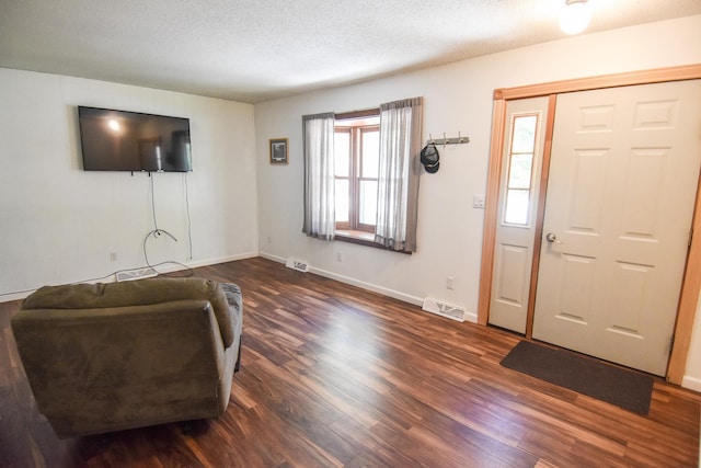 entrance foyer with a textured ceiling and dark hardwood / wood-style flooring