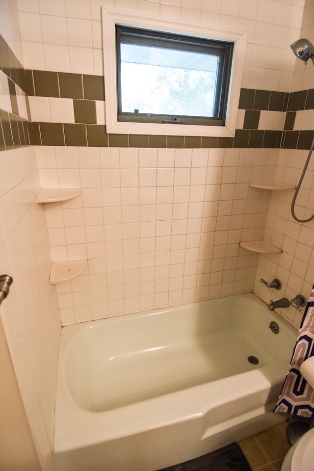 bathroom featuring tile patterned floors, tiled shower / bath, and toilet