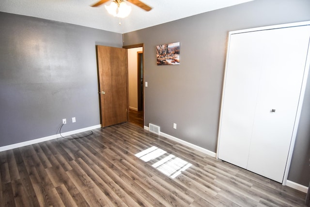 unfurnished bedroom with a closet, ceiling fan, dark wood-type flooring, and a textured ceiling