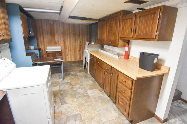 kitchen featuring wooden walls and washer / dryer