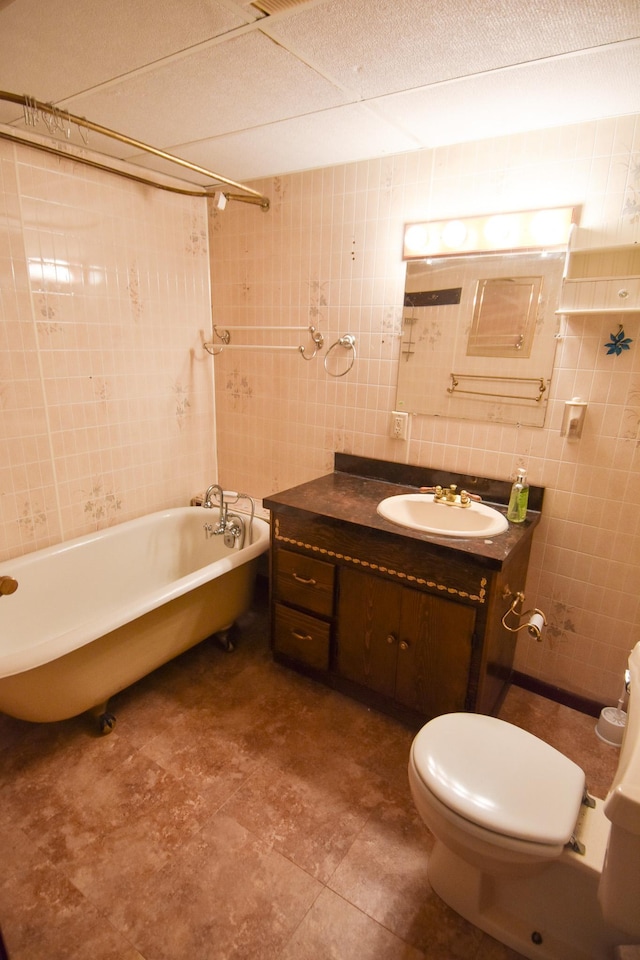 bathroom with vanity, tile walls, and toilet