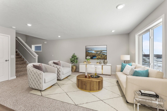 carpeted living room featuring a textured ceiling