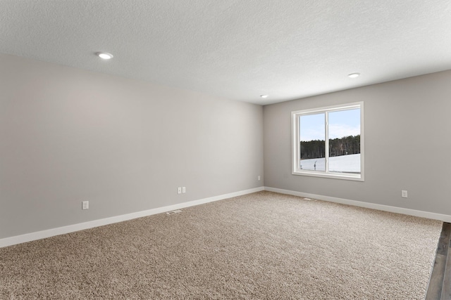 carpeted empty room with a textured ceiling