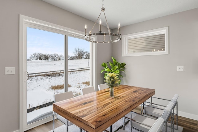 dining space with hardwood / wood-style floors and a chandelier