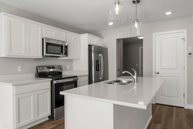 kitchen with white cabinetry, sink, an island with sink, pendant lighting, and appliances with stainless steel finishes