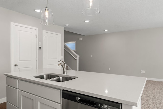 kitchen featuring pendant lighting, dishwasher, a kitchen island with sink, sink, and a textured ceiling