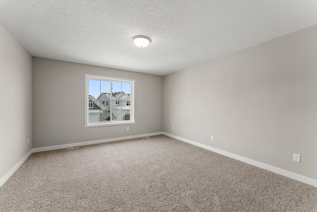 spare room with a textured ceiling and carpet floors