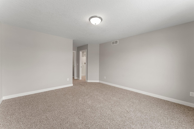 spare room with a textured ceiling and carpet floors