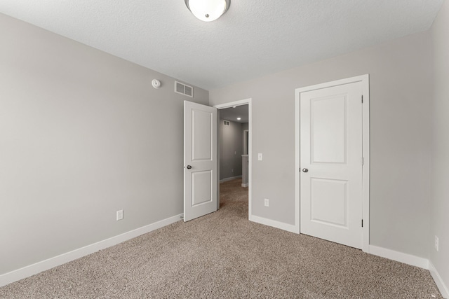 unfurnished bedroom with carpet floors and a textured ceiling