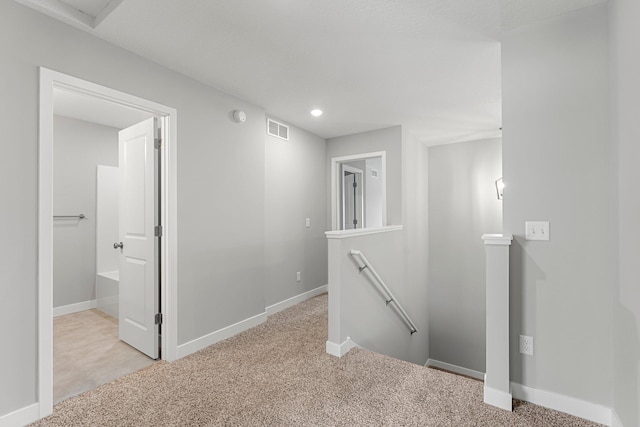 corridor with light colored carpet