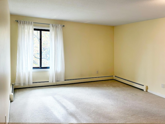 carpeted empty room featuring a baseboard radiator