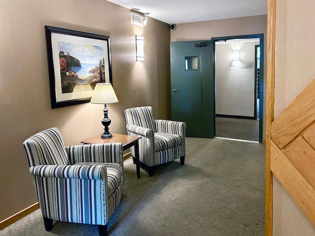 living area with dark carpet and a textured ceiling