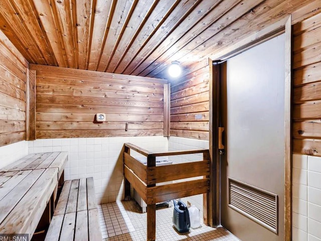 view of sauna featuring tile patterned flooring, wooden ceiling, and wooden walls