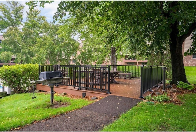 view of gate with a lawn and a deck