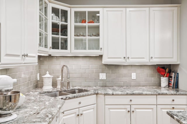 kitchen with white cabinetry, sink, and tasteful backsplash