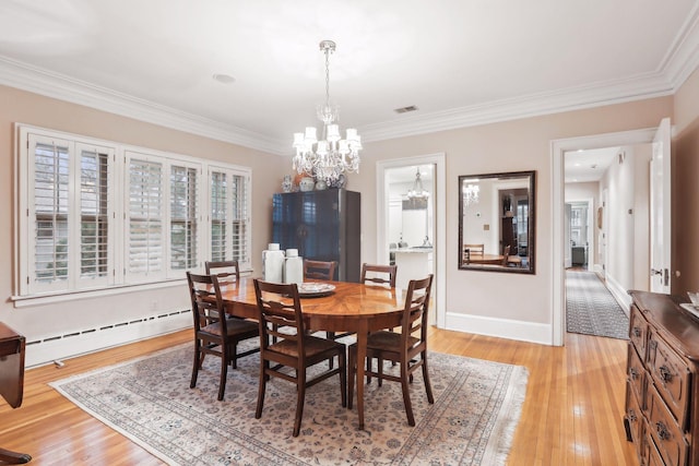 dining area with an inviting chandelier, light hardwood / wood-style flooring, crown molding, and a baseboard heating unit