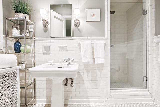 bathroom with tile walls and a shower with shower door