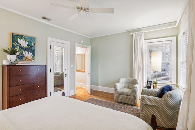 bedroom featuring crown molding, light hardwood / wood-style floors, and ceiling fan