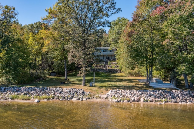 rear view of property with a yard and a water view