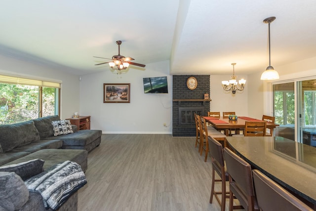 27734 Ridgewood Dr, Merrifield, MN 56465 - living room with light wood-style flooring, a brick fireplace, ceiling fan with notable chandelier, and baseboards
