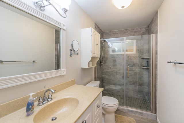 bathroom with vanity, hardwood / wood-style floors, toilet, and a shower with door