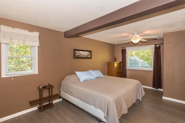 bedroom featuring a textured ceiling, beamed ceiling, dark hardwood / wood-style floors, and ceiling fan