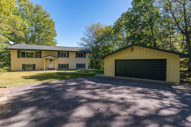 view of front facade with an outbuilding, a garage, and a front yard