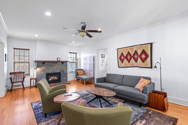 living room with a fireplace, ornamental molding, hardwood / wood-style floors, and ceiling fan