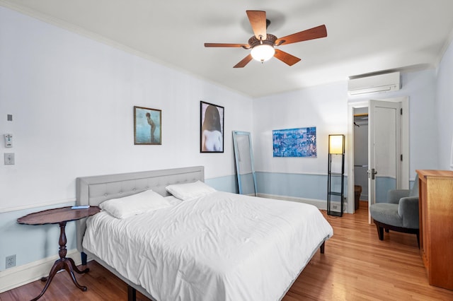 bedroom with light hardwood / wood-style flooring, ceiling fan, ornamental molding, and a wall mounted AC