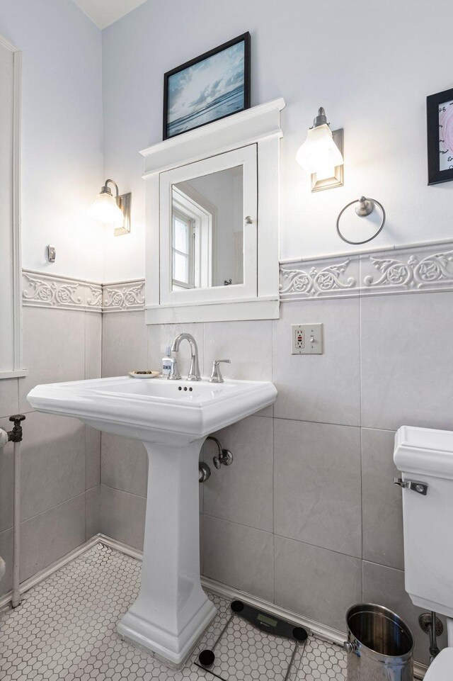 bathroom with tile walls, toilet, and tile patterned floors