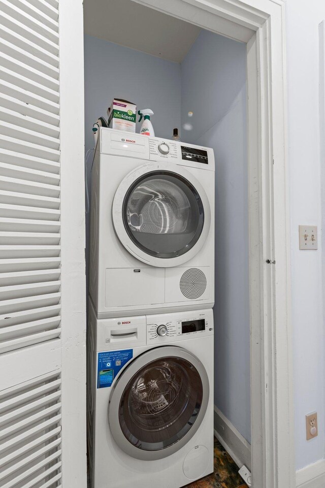 clothes washing area featuring stacked washer / dryer