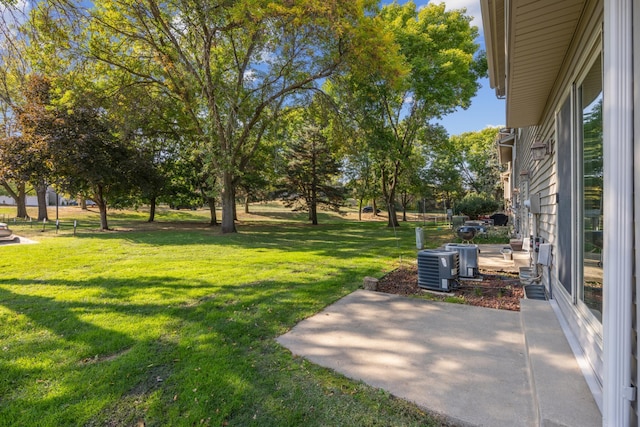 view of yard featuring central AC unit and a patio area