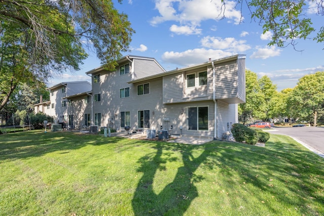 back of property with a lawn and a patio