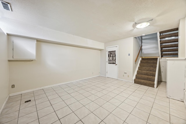 basement with a textured ceiling and light tile patterned floors