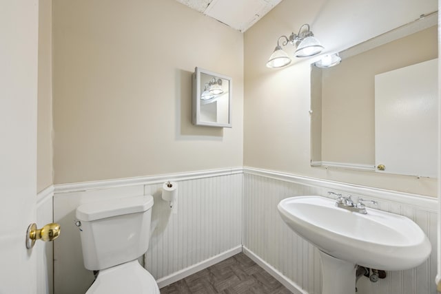 bathroom with parquet floors, sink, and toilet