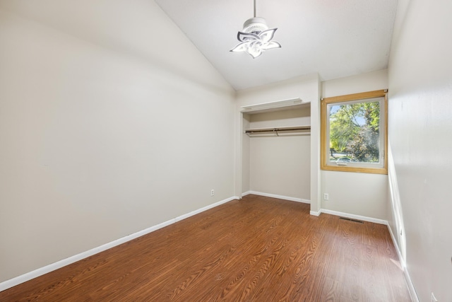 unfurnished bedroom featuring wood-type flooring, a closet, and vaulted ceiling