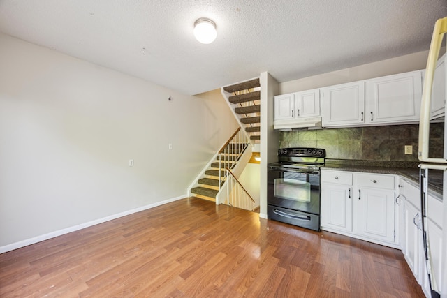 kitchen with decorative backsplash, wood-type flooring, white cabinets, and black electric range