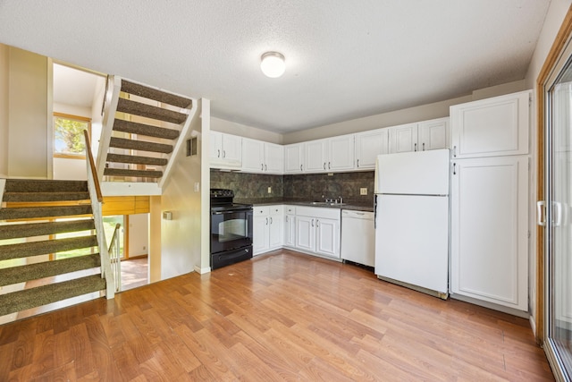 kitchen featuring white cabinets, sink, white appliances, light hardwood / wood-style floors, and decorative backsplash