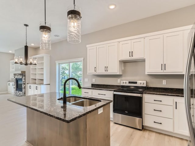 kitchen featuring decorative light fixtures, appliances with stainless steel finishes, a chandelier, and white cabinets