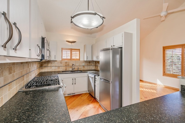 kitchen with appliances with stainless steel finishes, decorative backsplash, white cabinetry, light hardwood / wood-style flooring, and sink